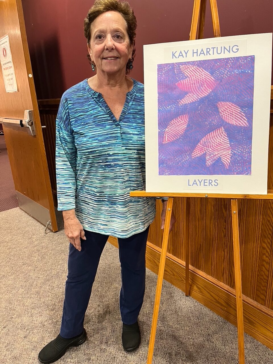 Artist Kay Hartung by the entrance to her exhibit at the Acton Memorial Library. 
