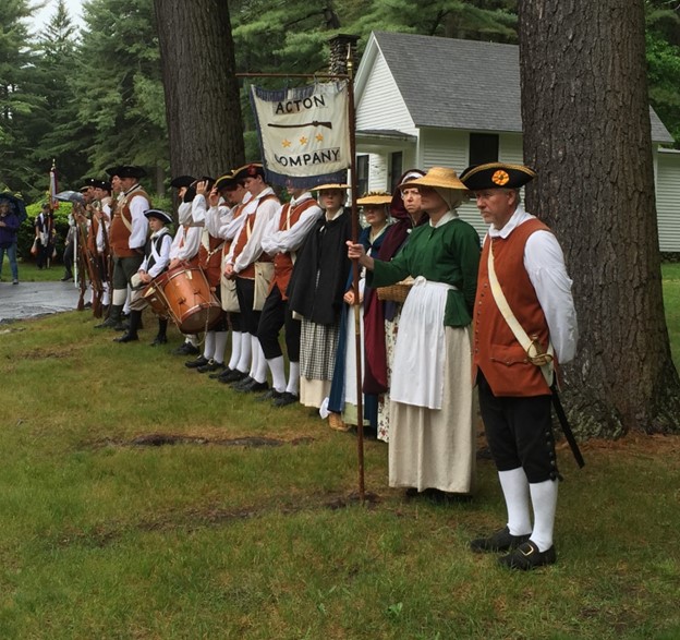 A group of people in Colonial garb stand at attention at Mount Hope Cemetery.