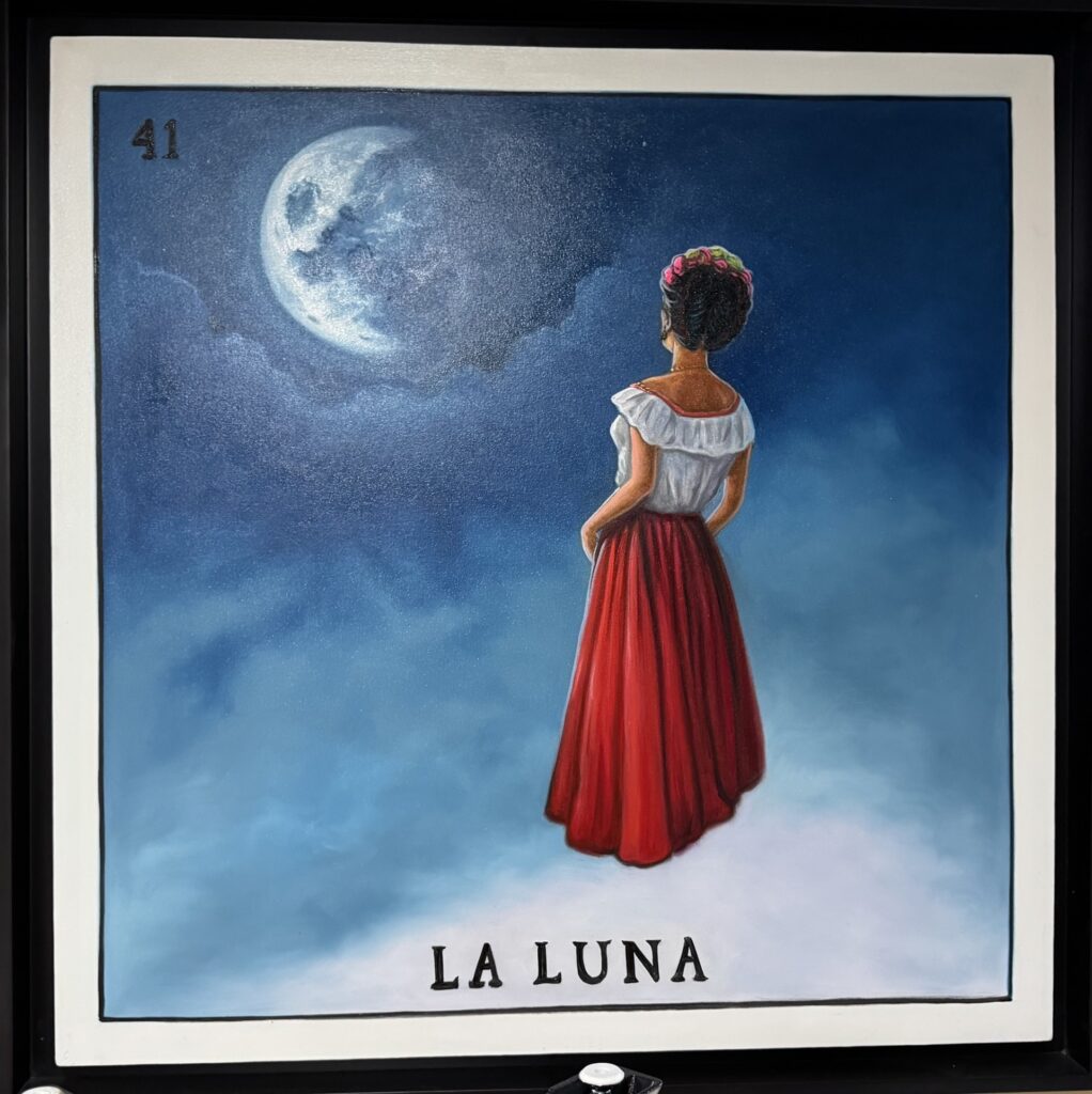 A picture of a woman looking at a full moon. Only the back of the woman appears. She's wearing a white off the shoulder blouse and a long red skirt. The bottom of the picture says "La Luna."