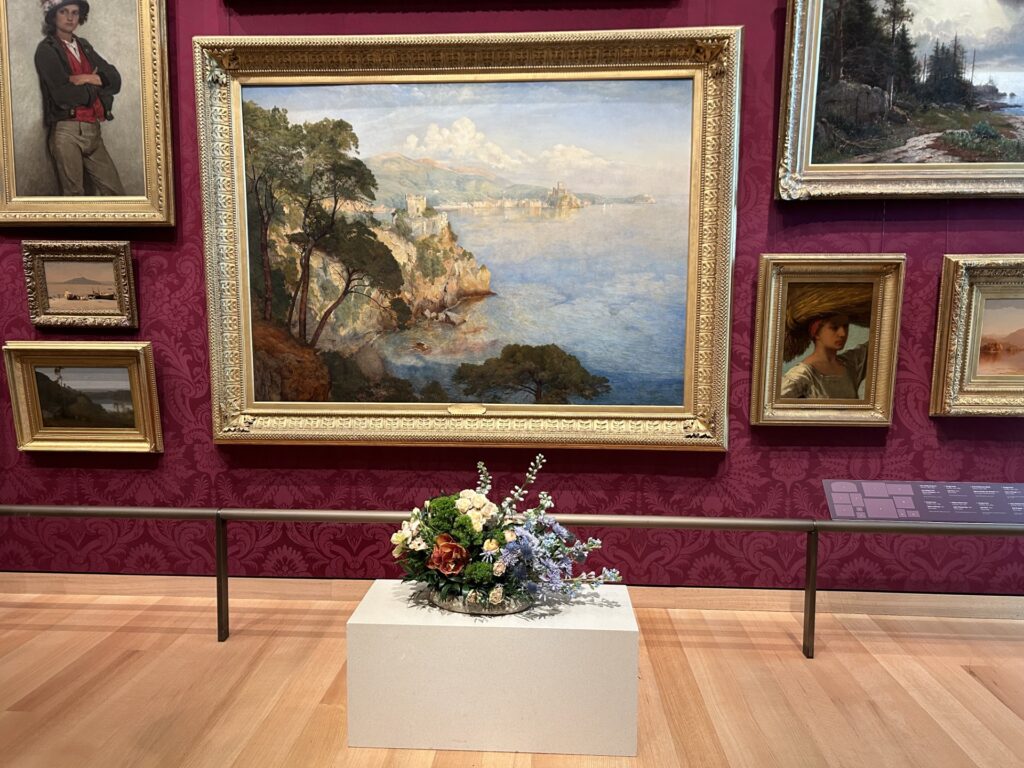 A romantic-era painting of a gulf, with a pay off in the distance in muted colors. A lower arrangment stands in front reflecting the same colors and evoking a cloudy day.