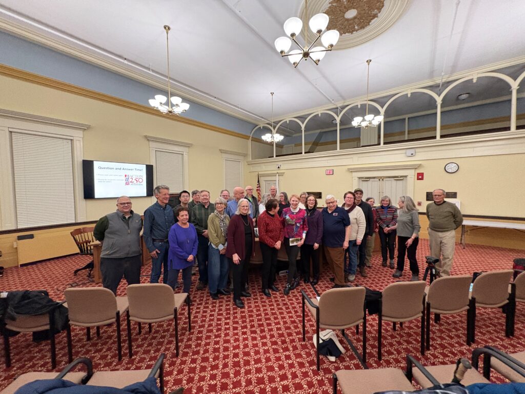 A group of people posing with the artist in Room 204 of Town Hall.