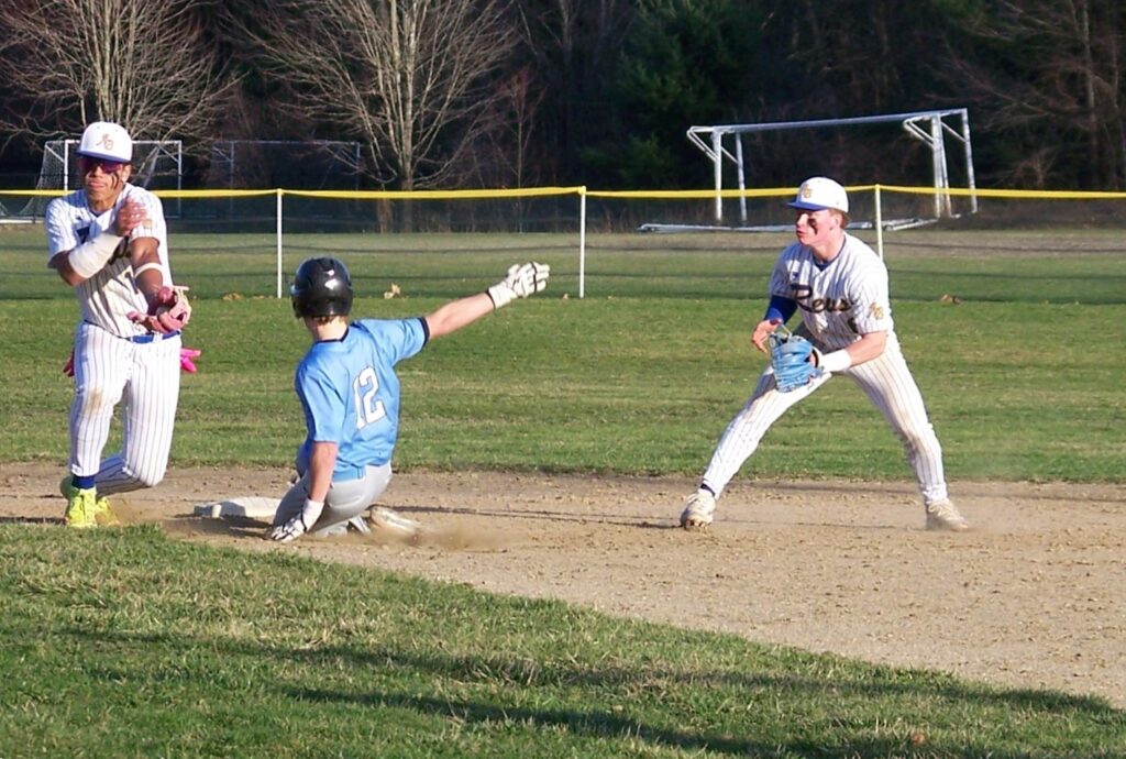 A Lexington player slides into a base while two Revs players wait for a ball.