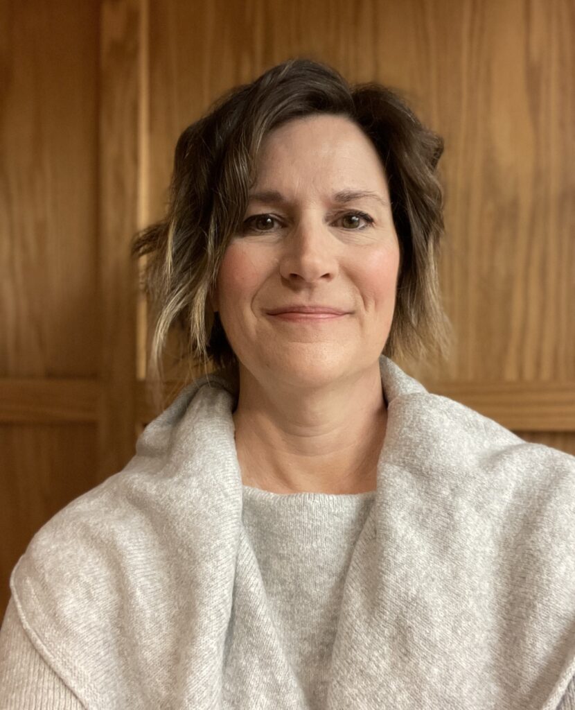 A woman with shortish hair wearing an off-white sweater.