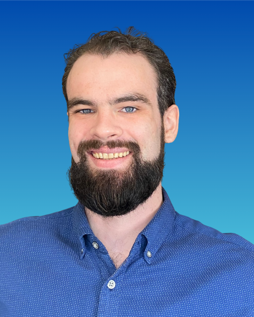 A smiling youngish man with an impressive beard.