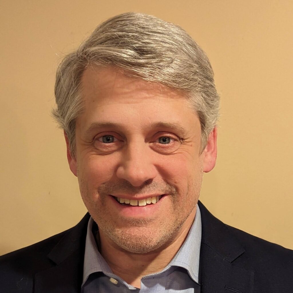 A smiling grey-haired man.