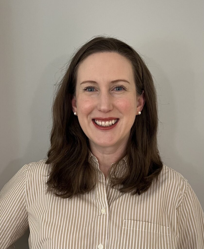 A smiling woman with shoulder-lenght brown hair.