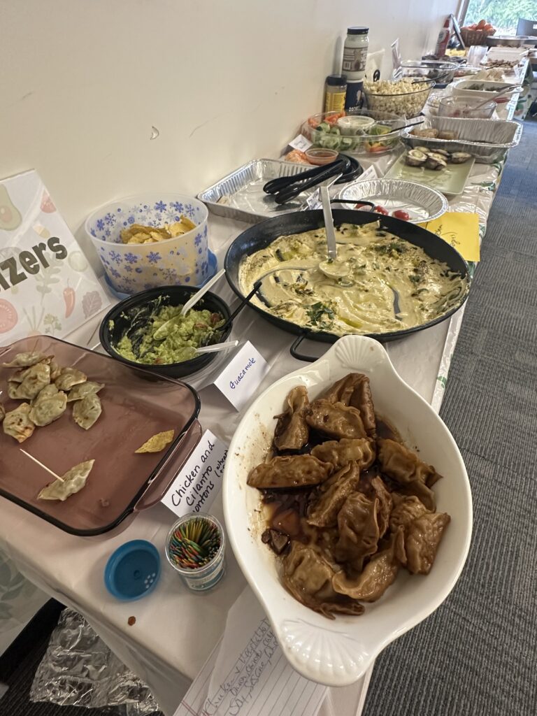 Several tables full of different kinds of food.